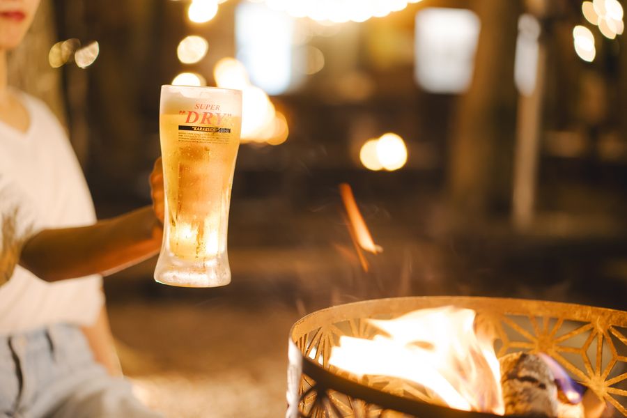 たき火の前に置かれた生ビール