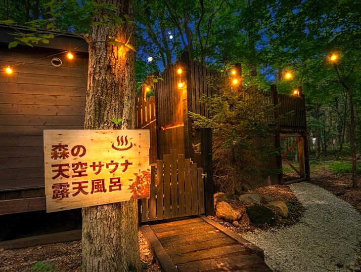 夜の森にともる「森の天空サウナ・露天風呂」の入口
